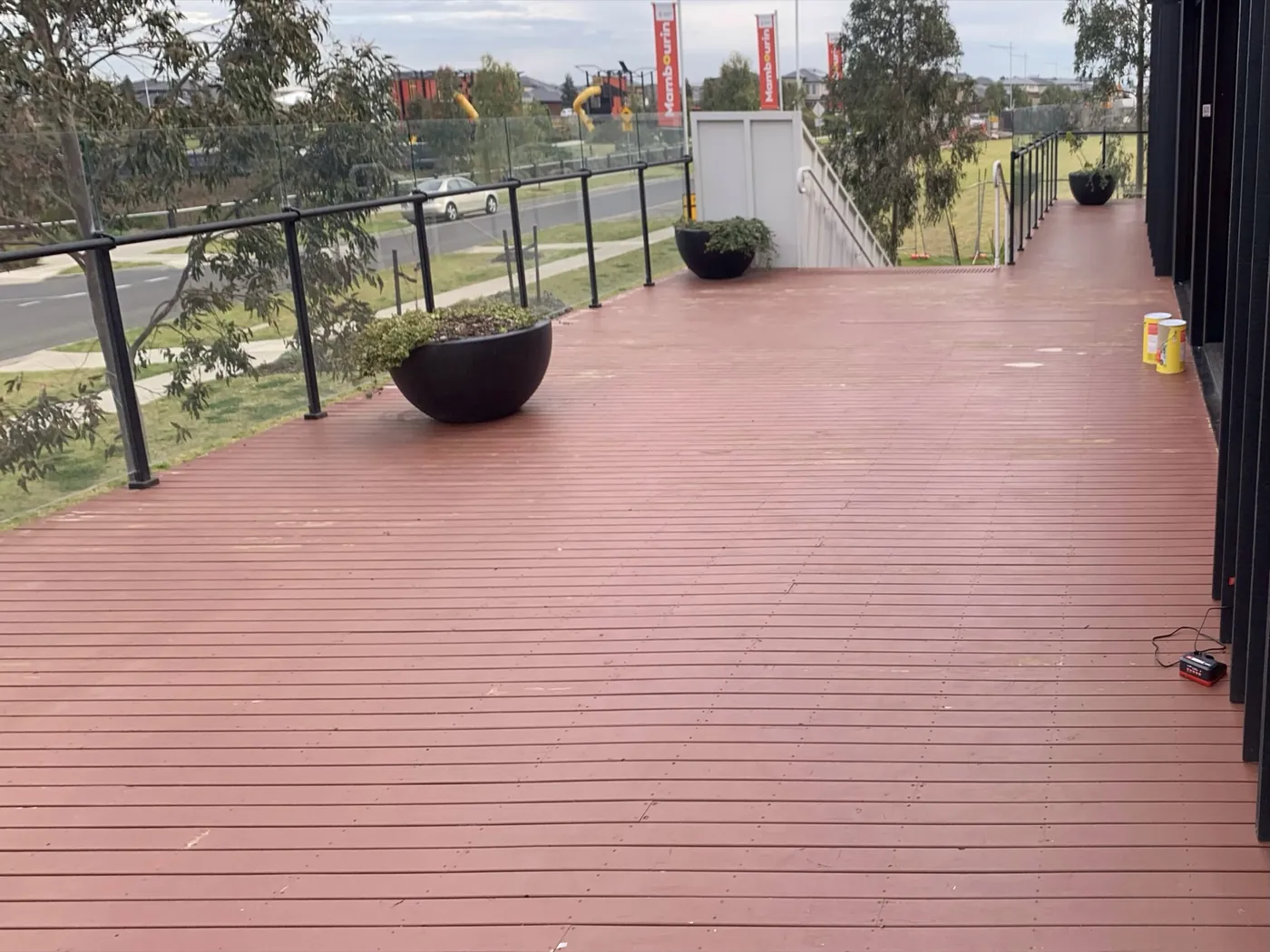 Open terrace before, worn red decking with planters, Point Cook