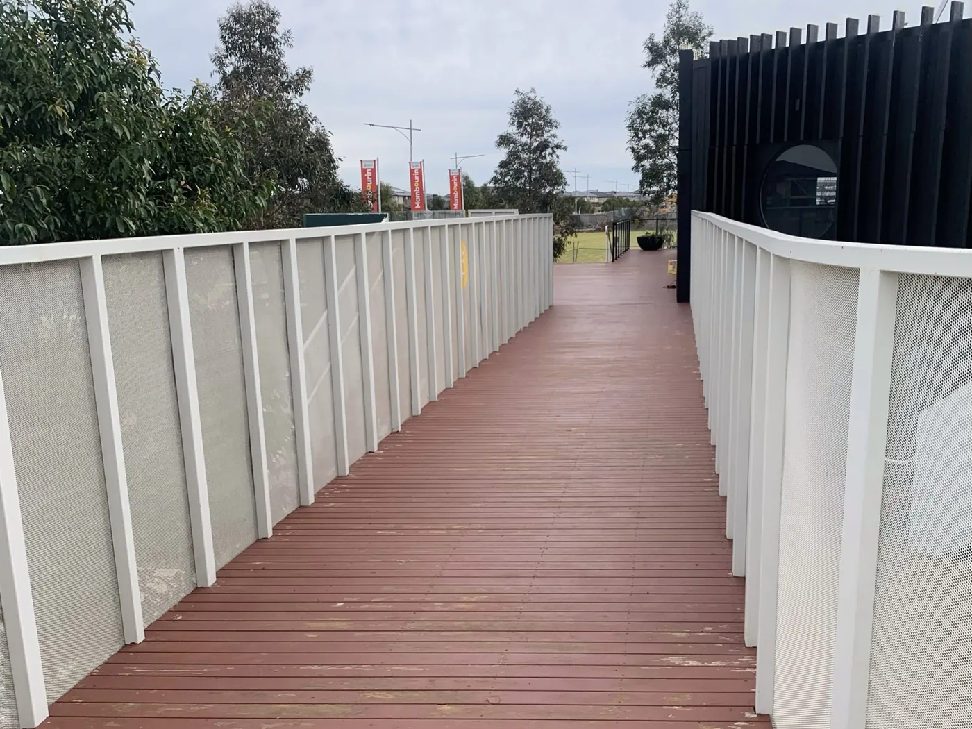 Community centre access ramp before, worn red timber decking, Point Cook