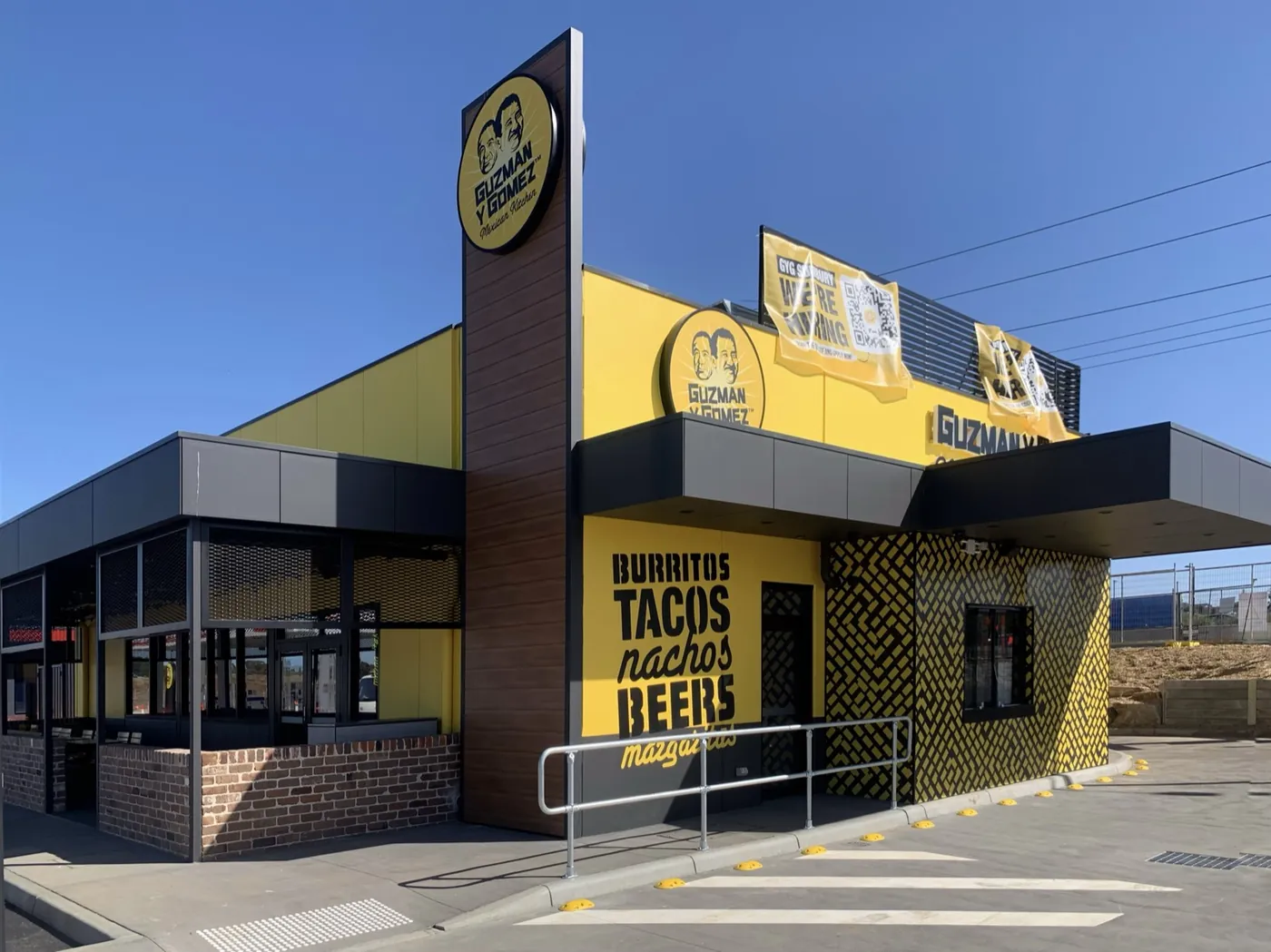 Guzman Y Gomez drive-through restaurant painted in the brand's yellow and charcoal, Melbourne, Sunbury