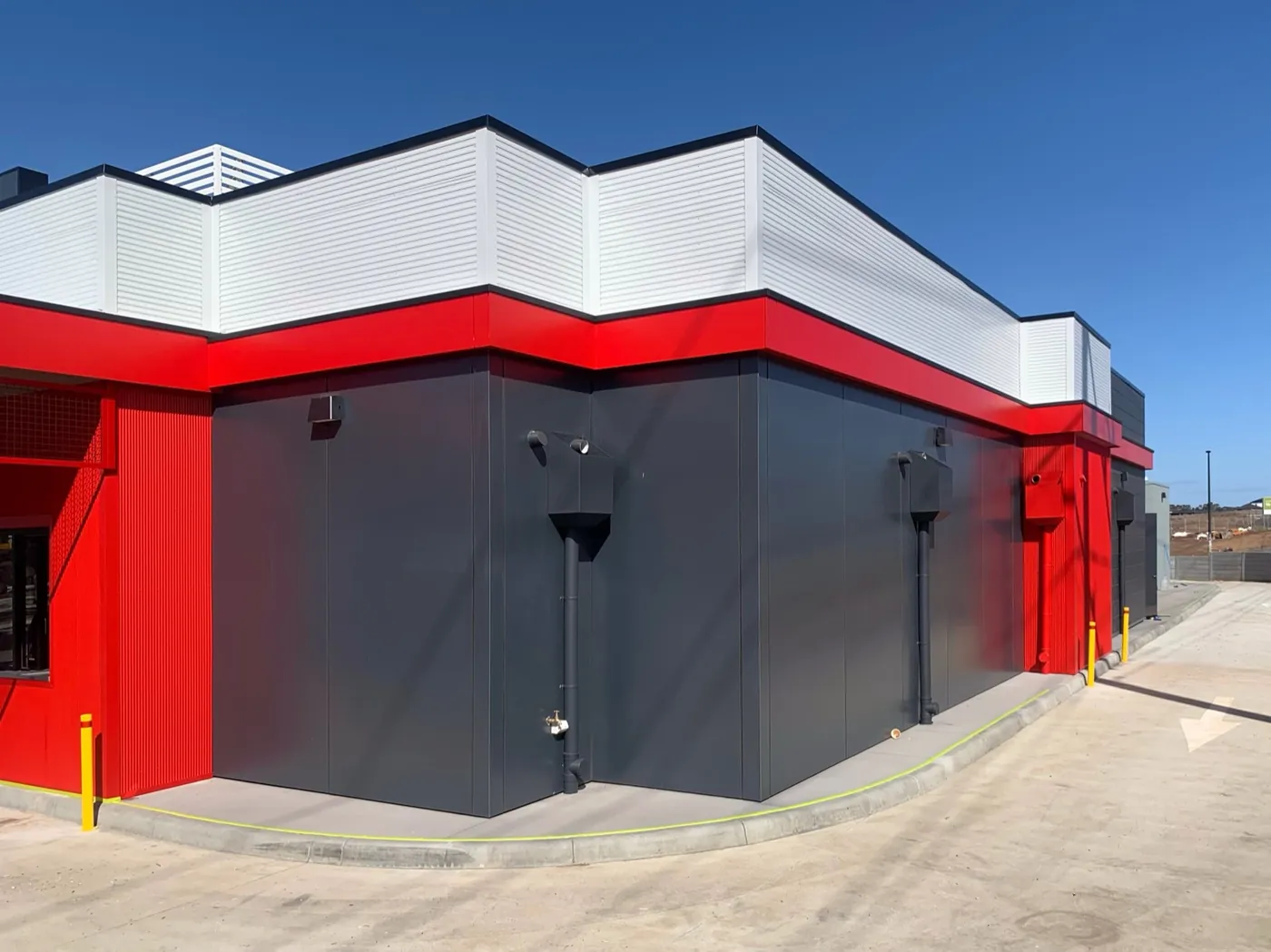7-Eleven building corner in red, charcoal and white bands, Sunbury