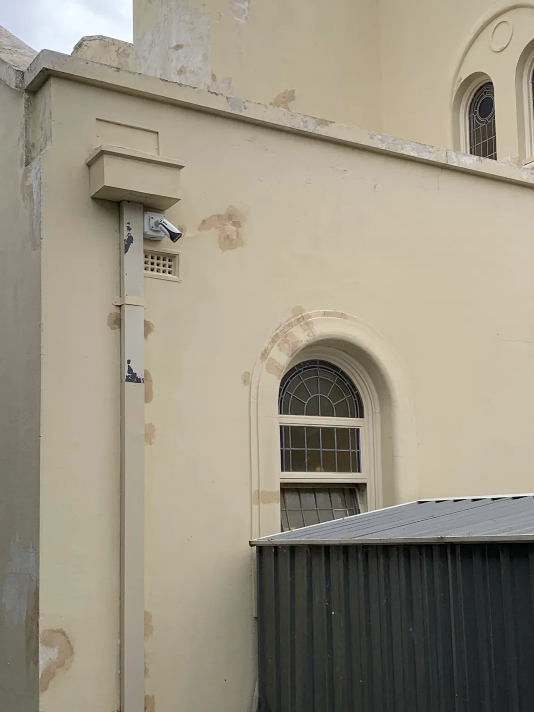 Side wall of the heritage building before, blistered and stained render