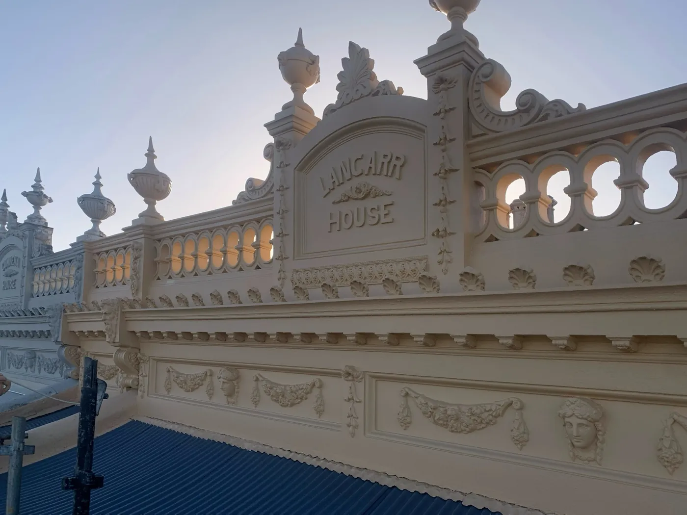 Detail of the Lancarr House parapet, classical swags, shell motifs and urns picked out in cream, Carlton