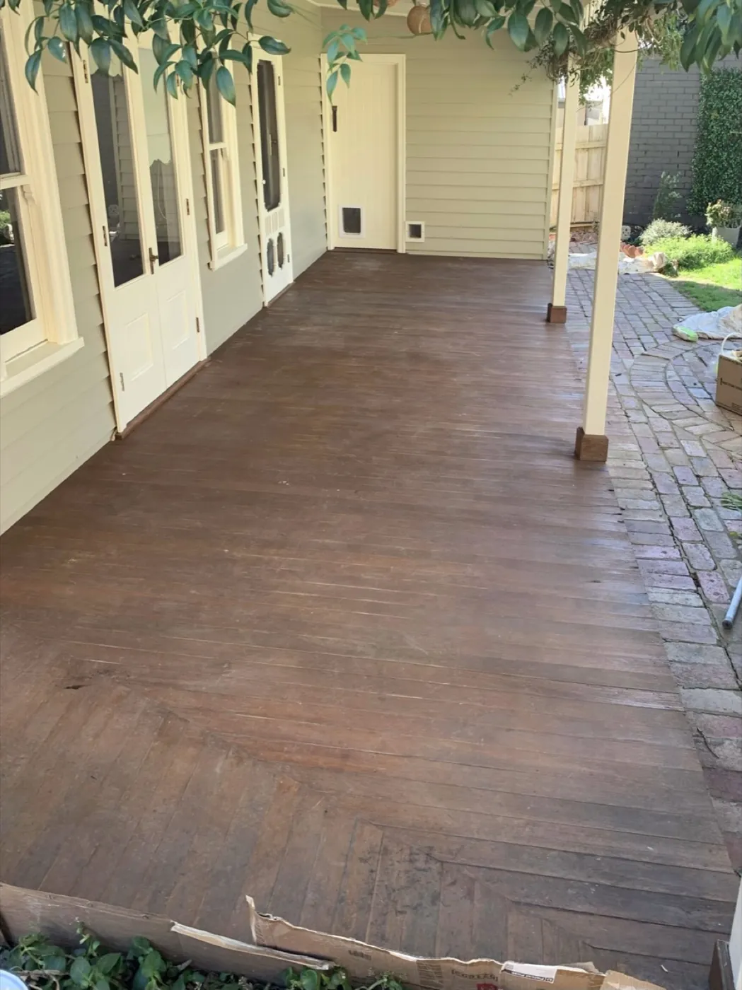 Period verandah floor before, worn brown boards