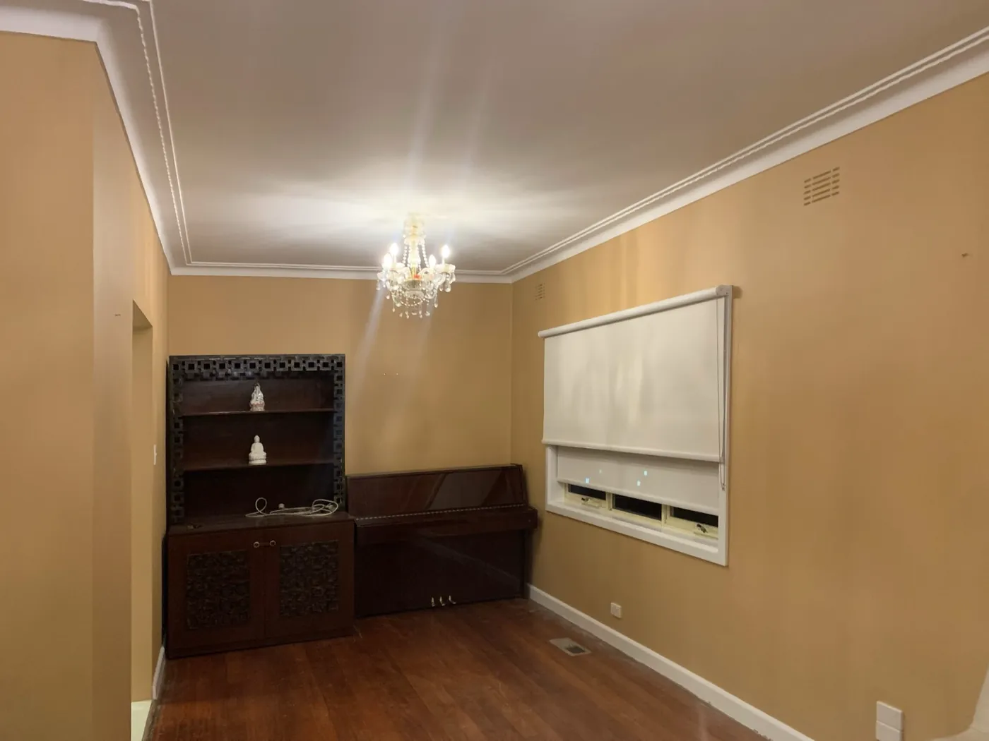 Finished living room, apricot walls under a white moulded cornice, Oakleigh