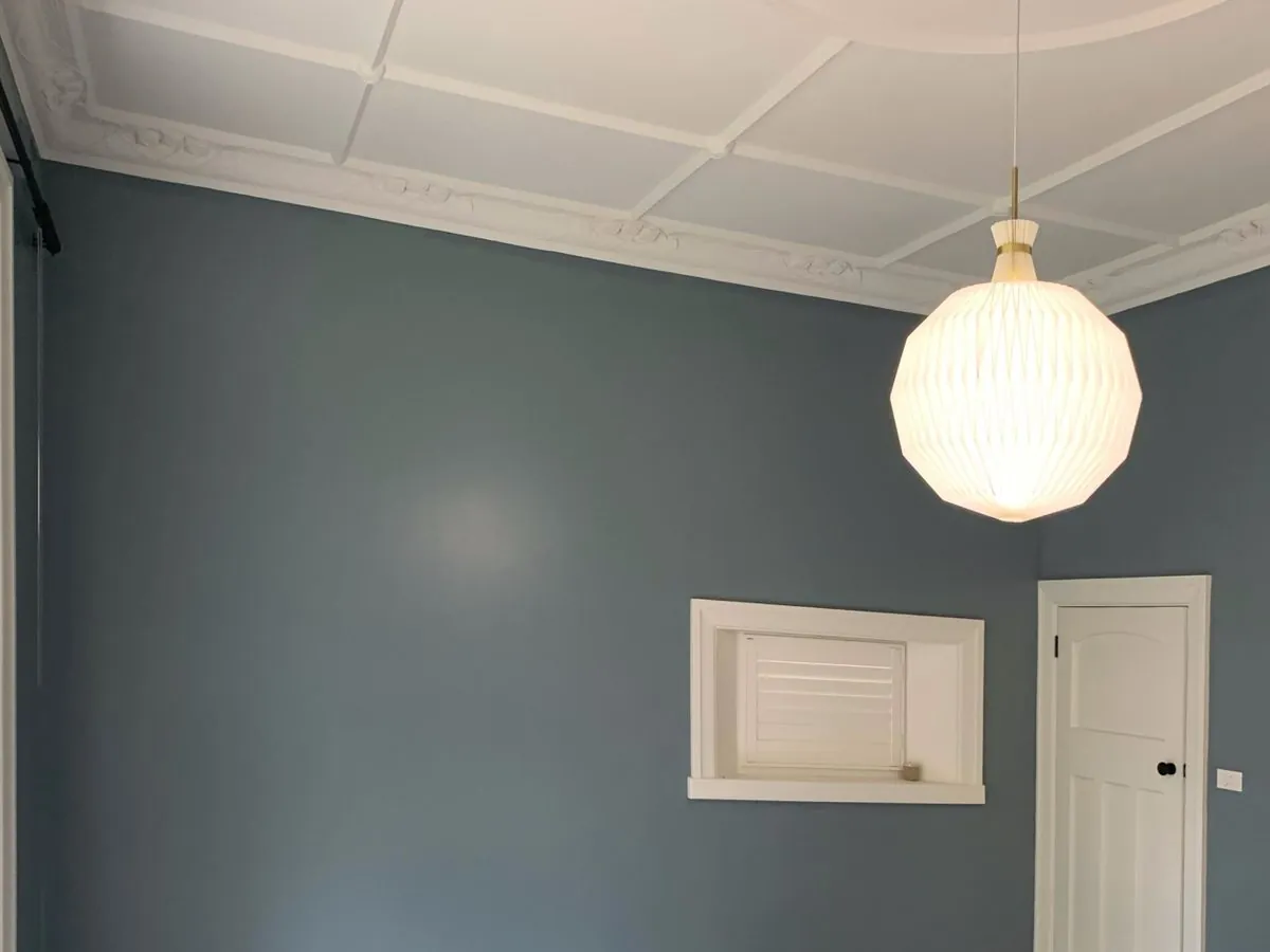 Period room painted in deep blue grey with a white ornate cornice