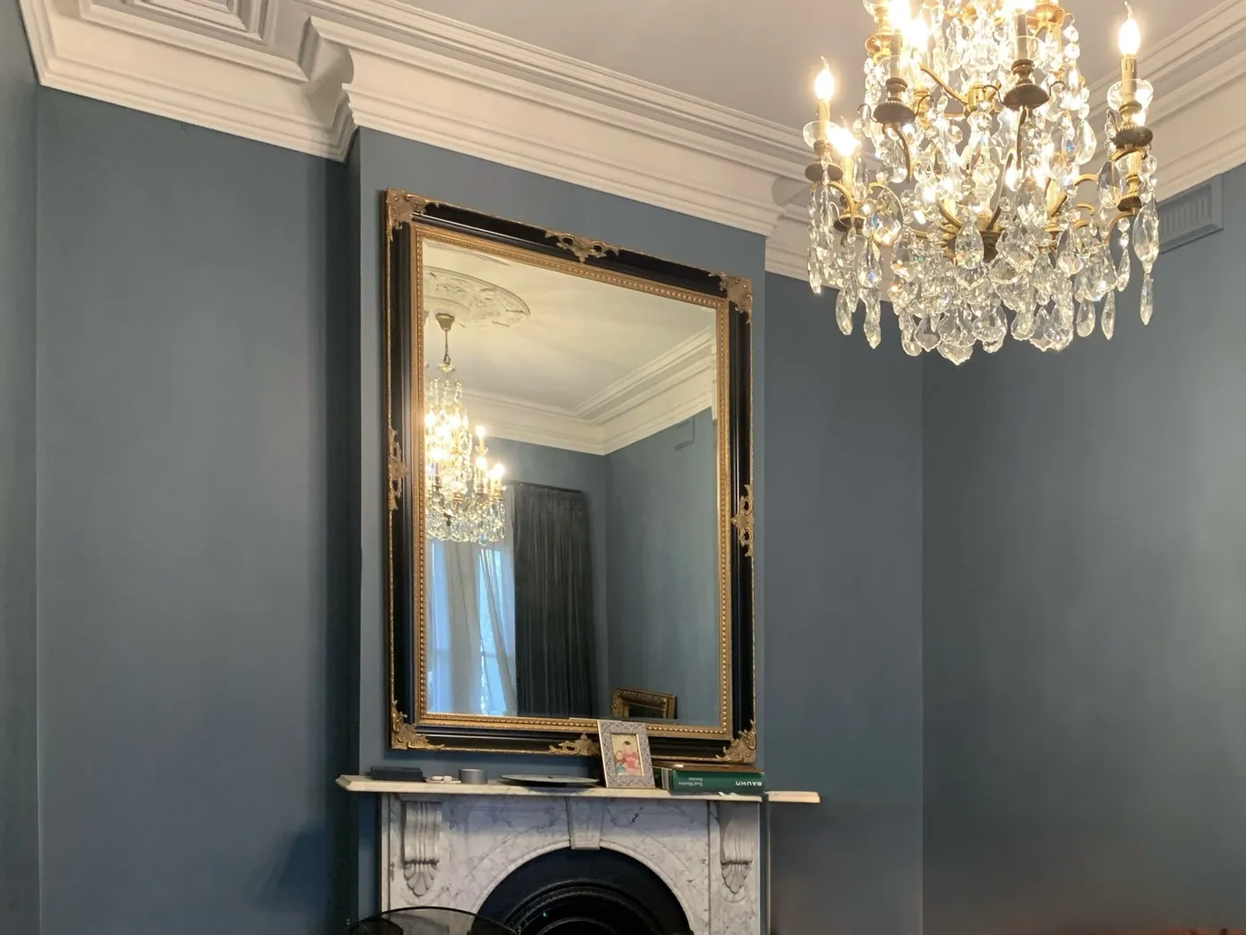 Victorian room in Melbourne repainted in deep blue grey, with a white cornice, marble fireplace, gilt mirror and