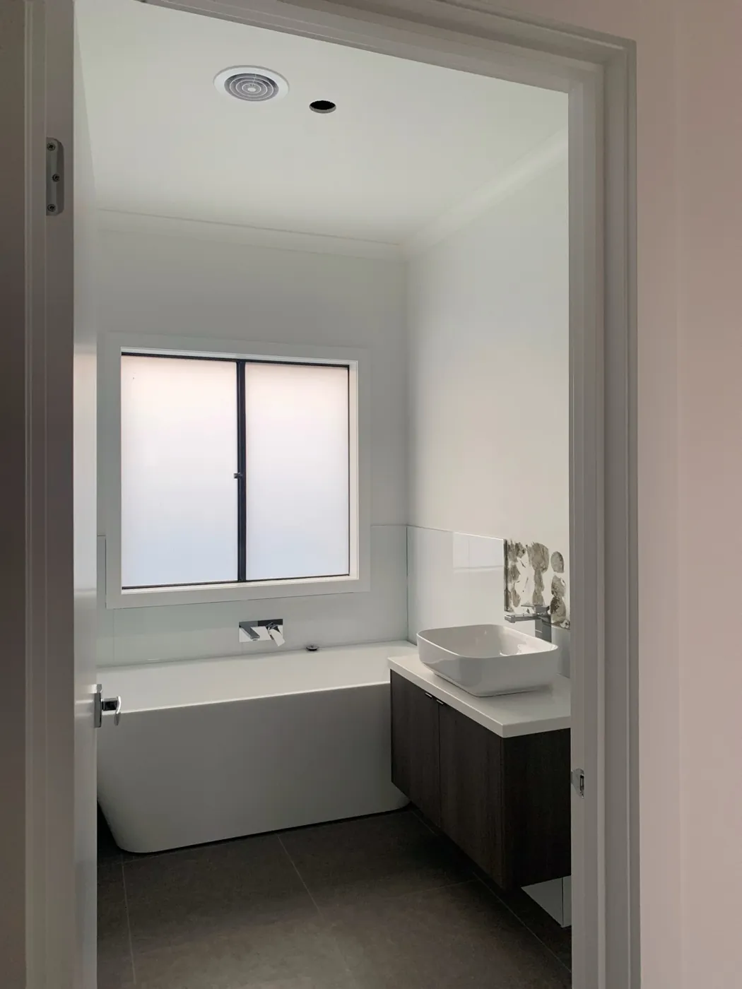 Bathroom in a new home, white walls and ceiling with a freestanding bath and vanity, Melton