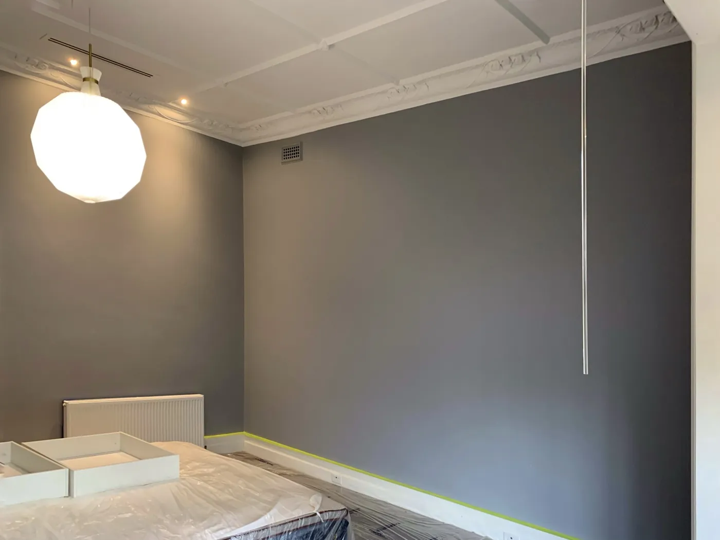 White ornate cornice and ceiling cut in by hand against deep blue grey walls, Brighton