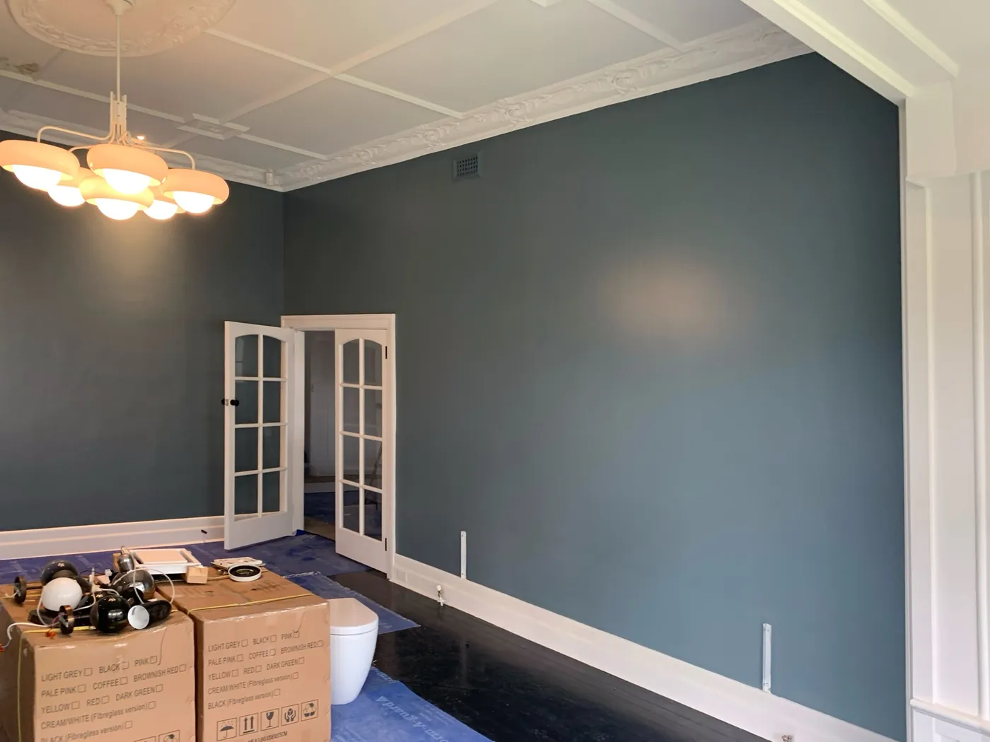 Blue grey room with white French doors and a deep panelled cornice over dark timber floor, Brighton