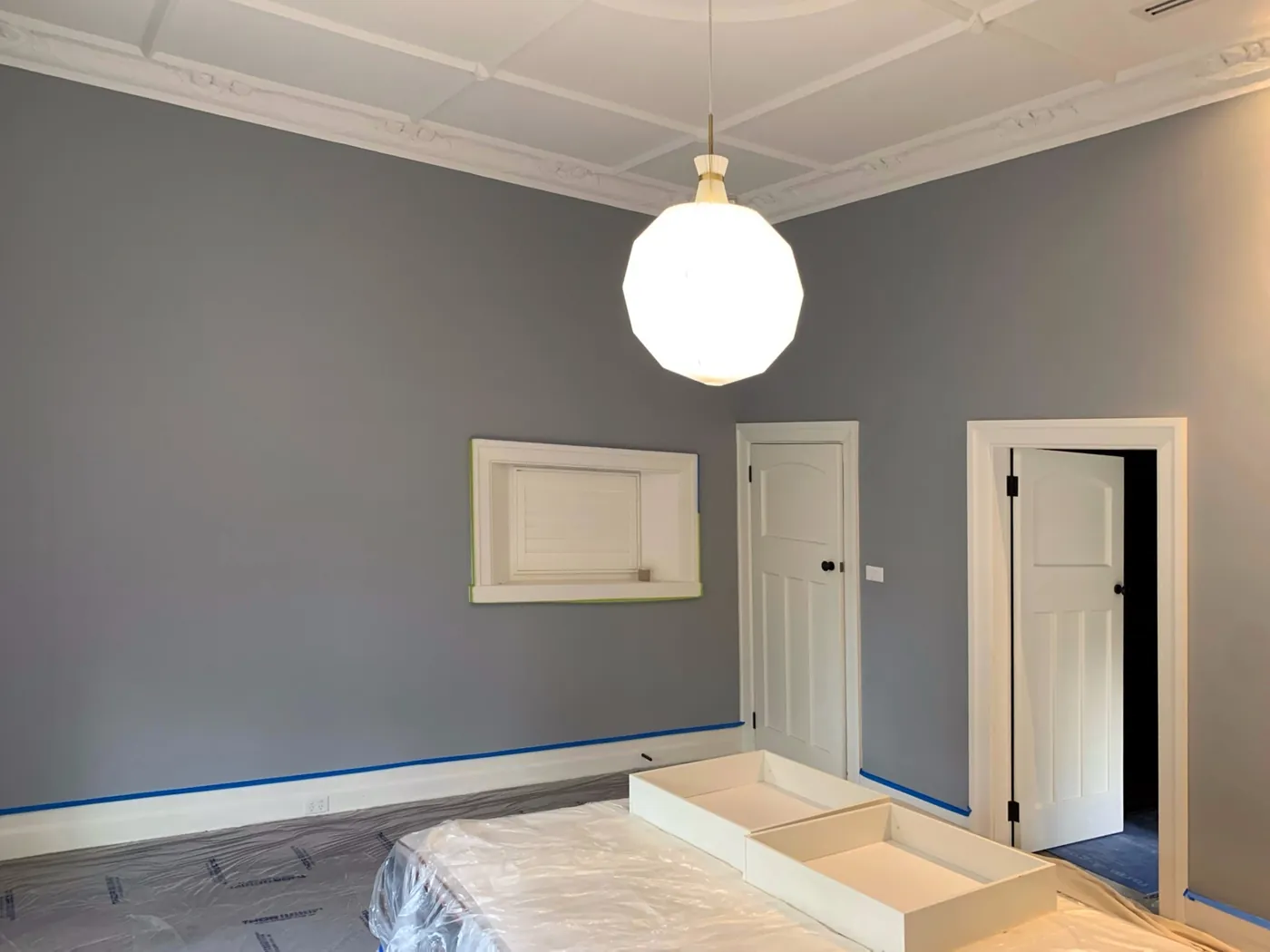 Blue grey wall with a white plaster niche and two panelled doors cut in clean, Brighton