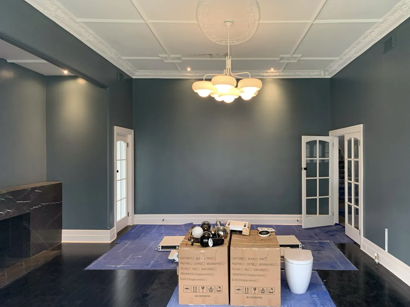 Period room in Brighton painted deep blue grey with a white ceiling rose, ornate cornice and marble fireplace