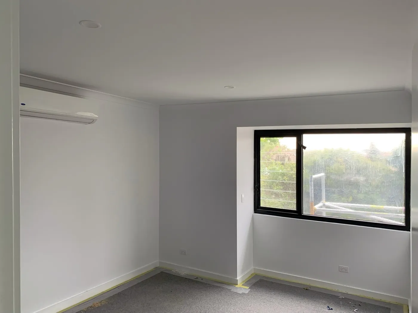 Same bedroom after, walls and ceiling painted with the black window frame cut in clean, Caulfield East