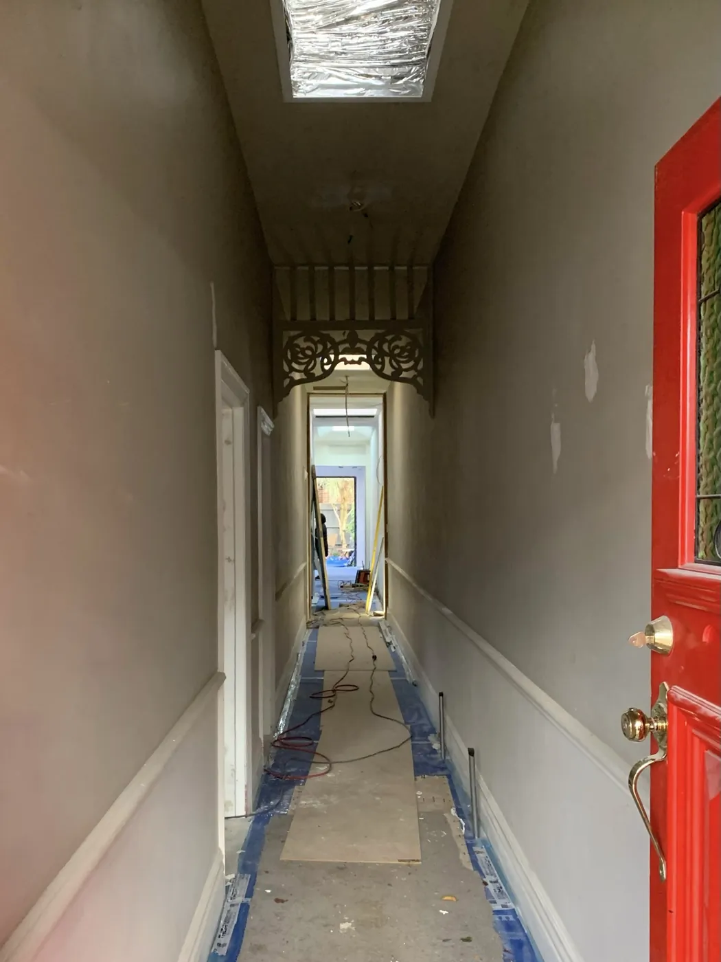 Entrance hall before, patched walls and dado with the floor boarded and taped, Armadale