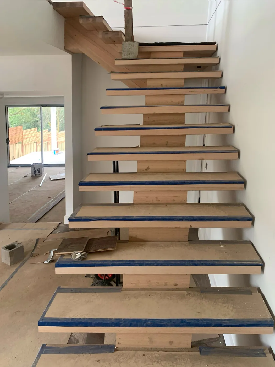 Open treads before, pale bare hardwood with masking tape, seen from below, Doncaster