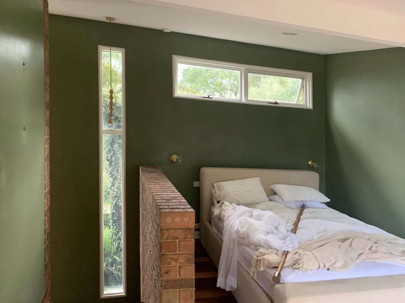Bedroom in deep olive behind an internal brick pier, with a tall narrow window, Ferntree Gully