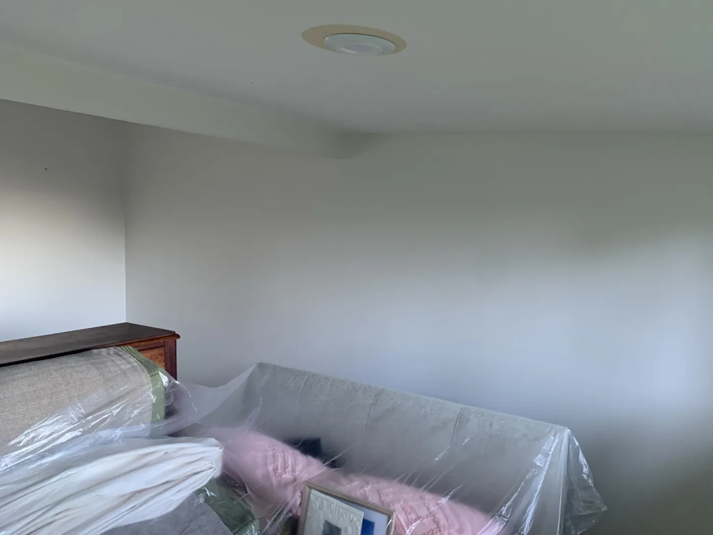 Bedroom before, white raked ceiling and walls with the bed sheeted in plastic, Ferntree Gully