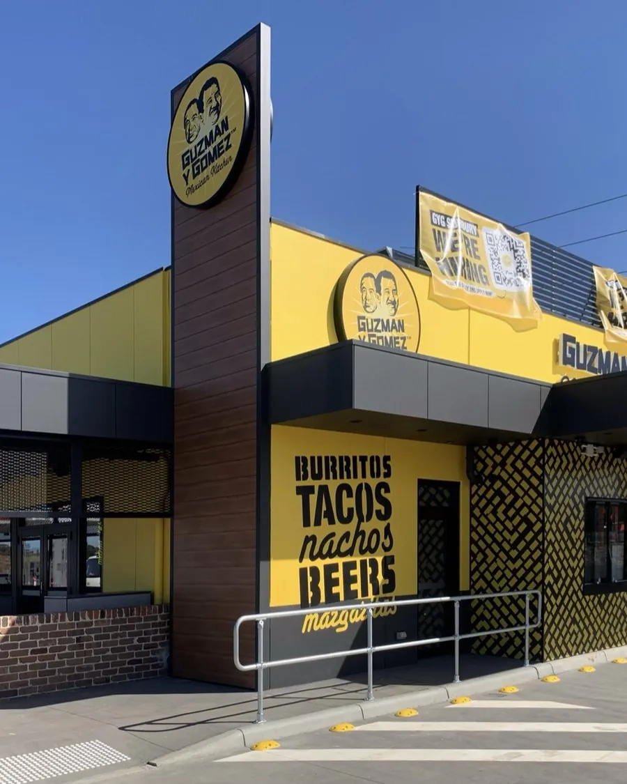 Painted yellow and charcoal facade of a Guzman Y Gomez restaurant, Melbourne, Sunbury