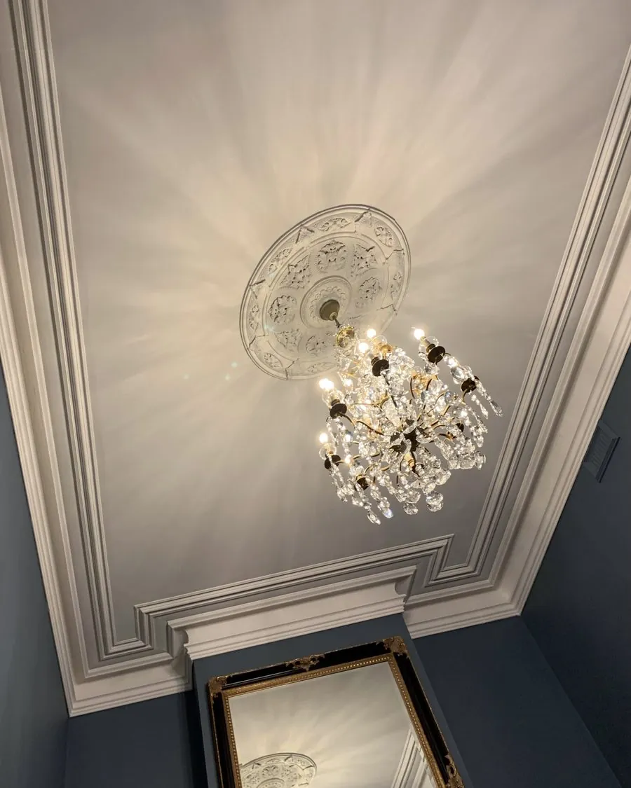 Ornate ceiling rose and cornice painted off white above deep blue walls, period home in St Kilda